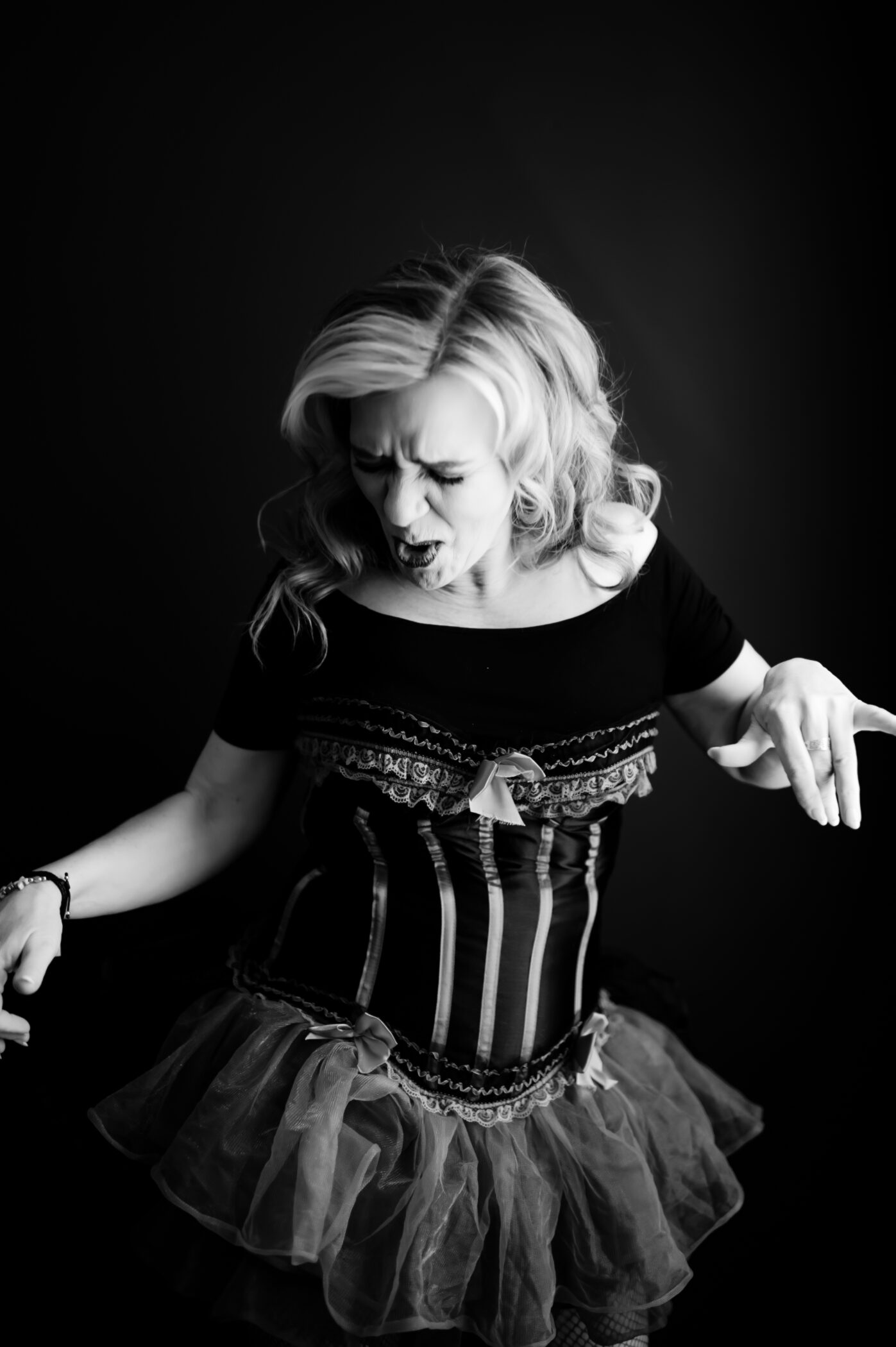 Woman wearing ruffled lingerie, dancing, photographed in black-and-white.