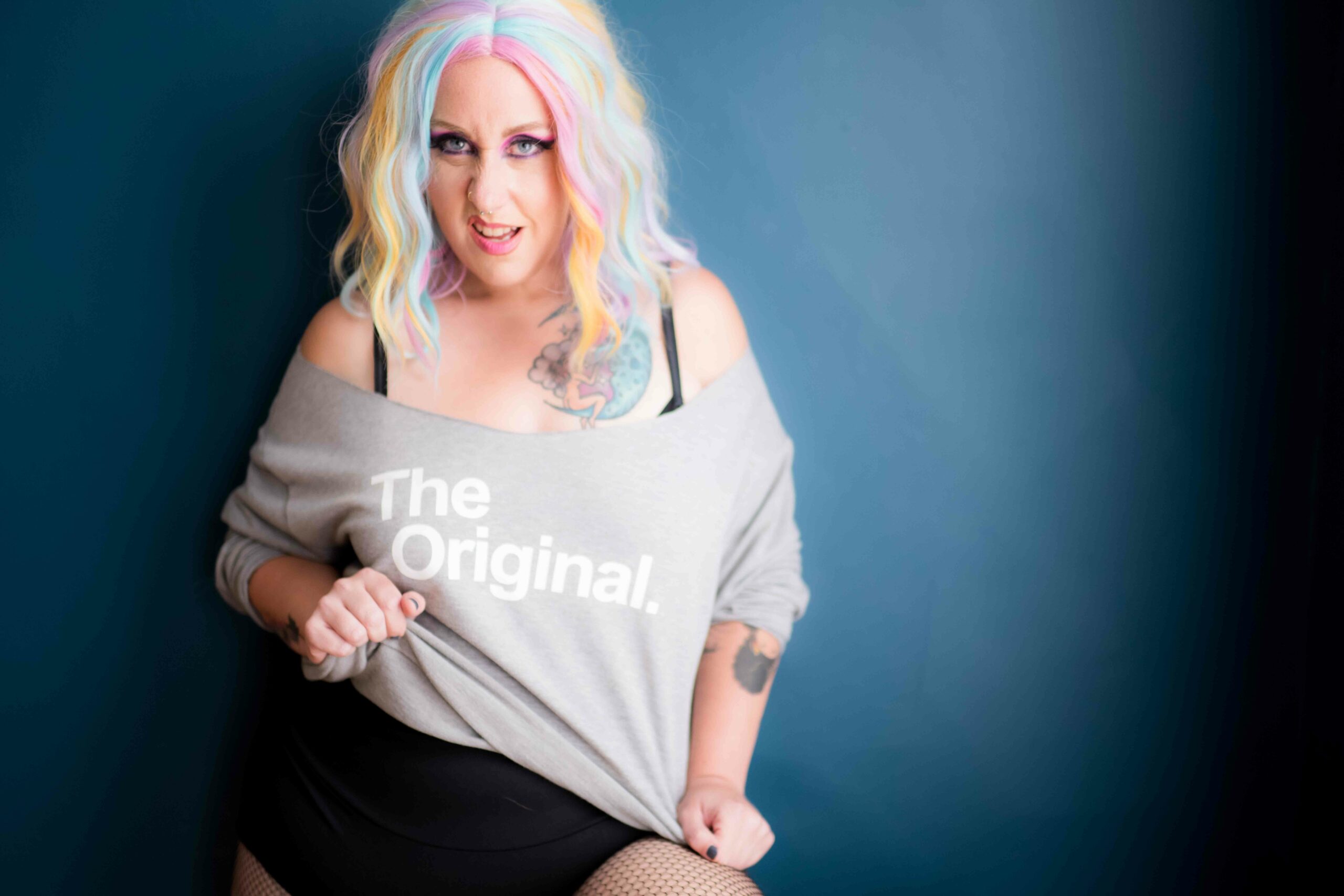 Photo of a woman with different colored strips on her hair. She's wearing a top with "The Original" text print.