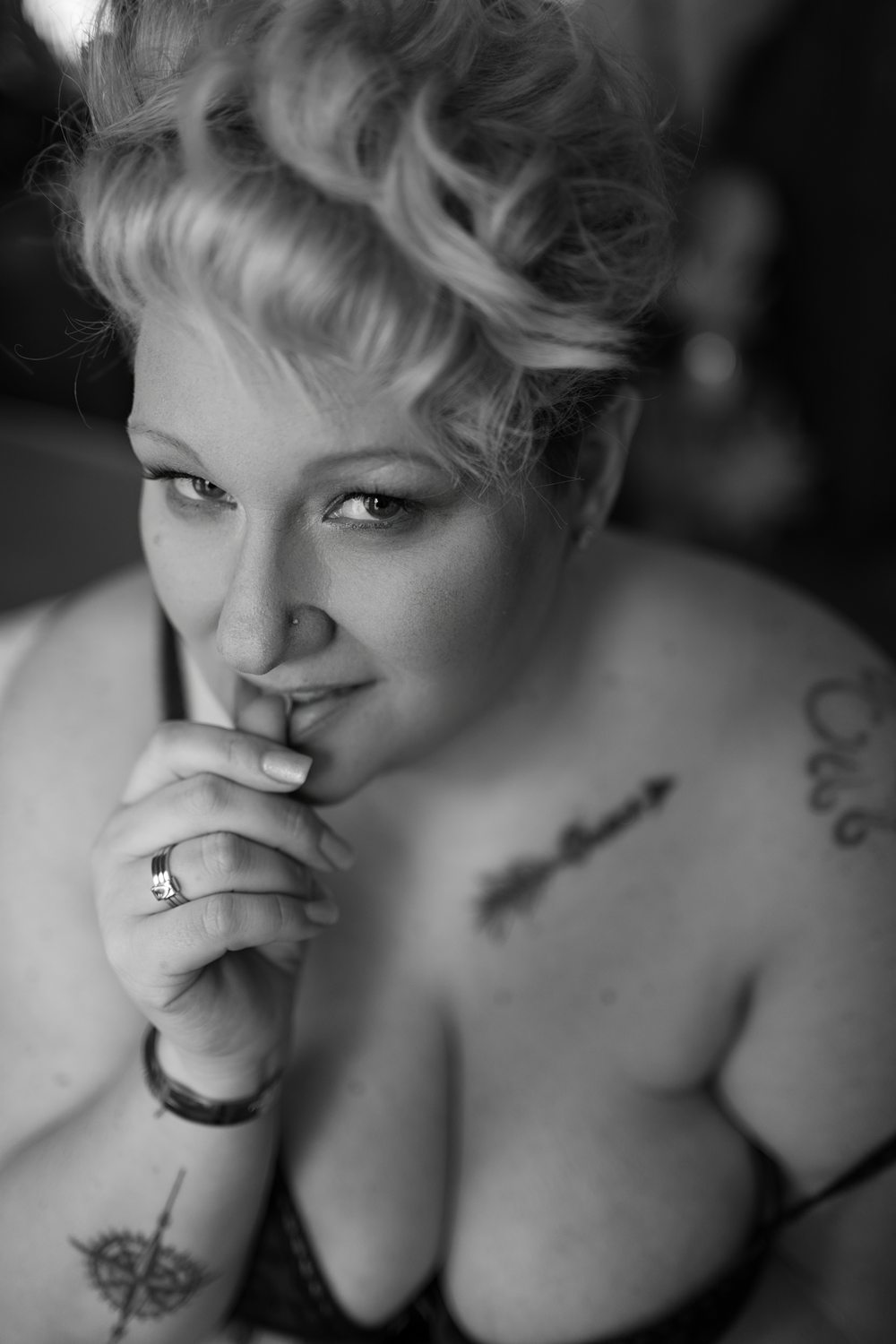 Seductive photo of woman biting her finger during emotive boudoir session with Betsy McCue Pictures.