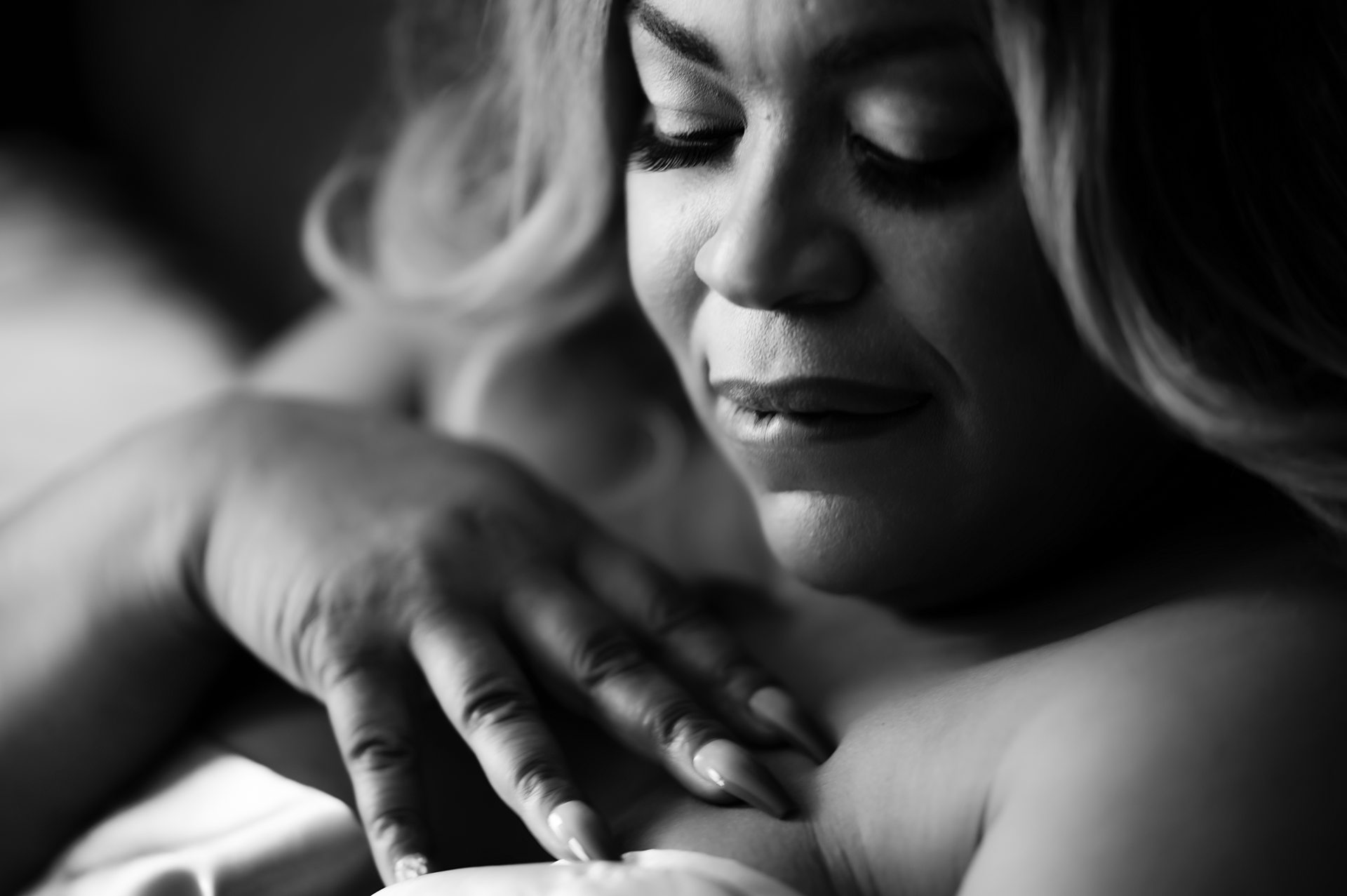 smokey moody bw boudoir photo in michigan with 40+ woman biting her lip